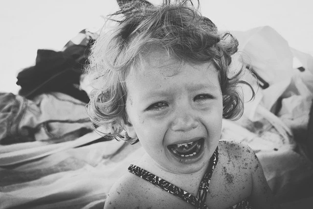 Une photo en noir et blanc d'une petite fille qui pleure.