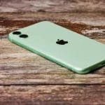 iPhone vert, table en bois.