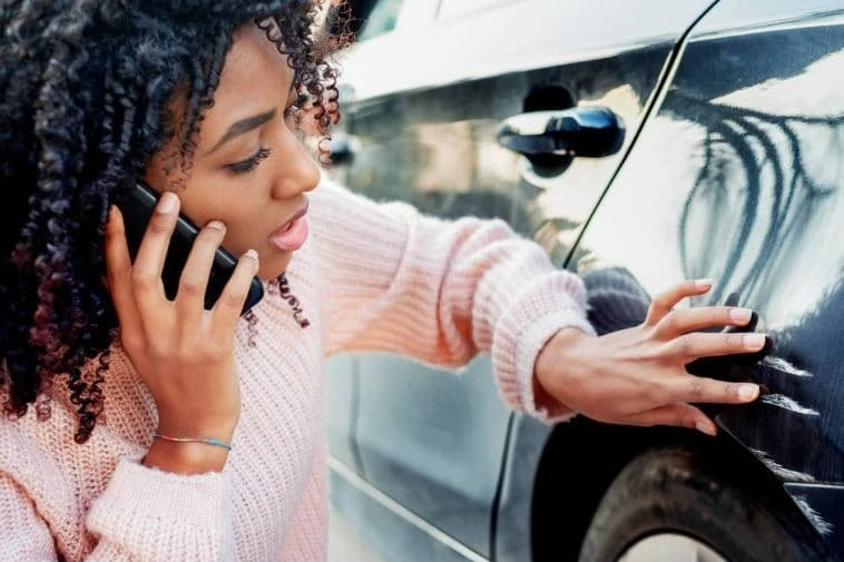 Une femme discutant des options de location de voiture après un accident.