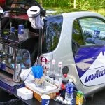 Une petite voiture avec une machine à café à l'arrière.