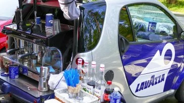 Une petite voiture avec une machine à café à l'arrière.