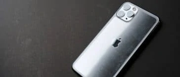 Il y a un iPhone 11 posé sur une surface noire.