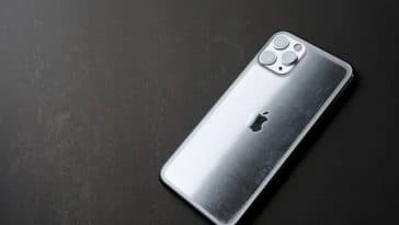 Il y a un iPhone 11 posé sur une surface noire.