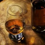 Une bouteille de whisky sur une table en bois.