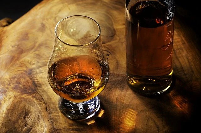 Une bouteille de whisky sur une table en bois.