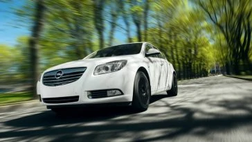 Une Opel Insignia blanche conduisant sur une route.