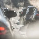 Une voiture émettant de la fumée circule dans les rues, posant un dilemme aux responsables de l'application d'une vignette anti-pollution.