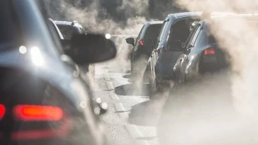 Une voiture émettant de la fumée circule dans les rues, posant un dilemme aux responsables de l'application d'une vignette anti-pollution.