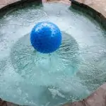 Une boule bleue flottante ajoute de l'ambiance à la soirée spa sous les étoiles.