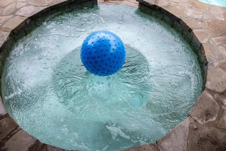 Une boule bleue flottante ajoute de l'ambiance à la soirée spa sous les étoiles.