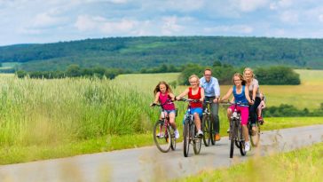 Un groupe de personnes faisant du vélo sur une route de campagne, profitant de la nature.