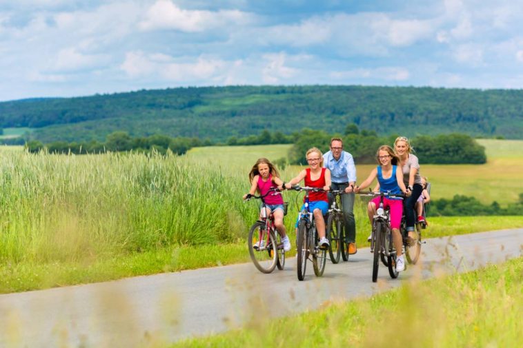 Un groupe de personnes faisant du vélo sur une route de campagne, profitant de la nature.