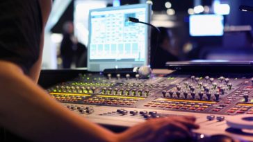 Tout savoir sur le mixage audio d'une personne travaillant sur une console de mixage.