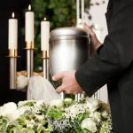Un homme pose une urne sur une table pendant le processus de crémation.