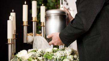 Un homme pose une urne sur une table pendant le processus de crémation.