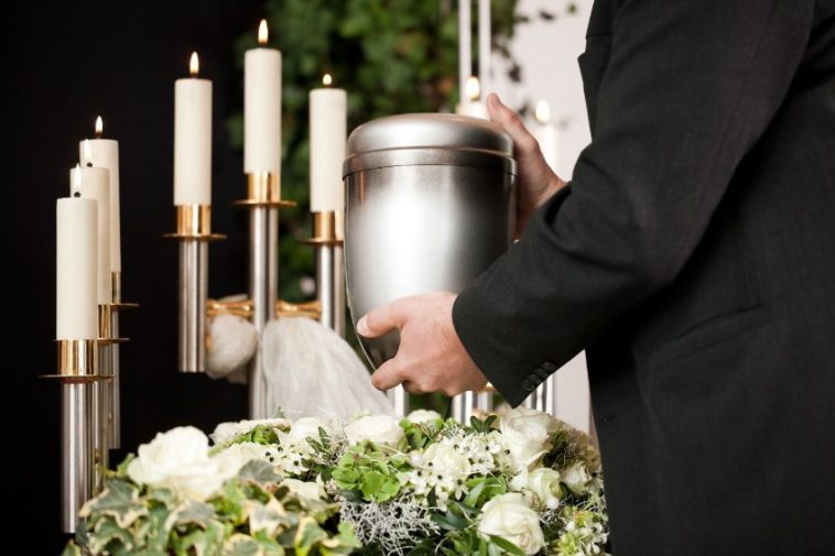 Un homme pose une urne sur une table pendant le processus de crémation.