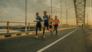 Un groupe de coureurs sur un pont participant à un événement sportif.