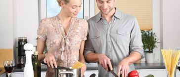 Un couple prépare de la nourriture dans sa cuisine tout en utilisant des surnoms mignons l'un pour l'autre.