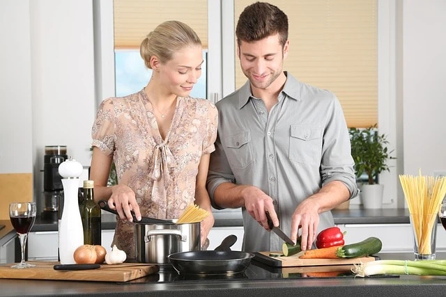 Un couple prépare de la nourriture dans sa cuisine tout en utilisant des surnoms mignons l'un pour l'autre.