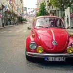 Une Volkswagen Beetle rouge garée sur le côté d'une rue.