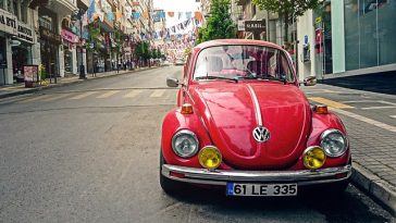 Une Volkswagen Beetle rouge garée sur le côté d'une rue.