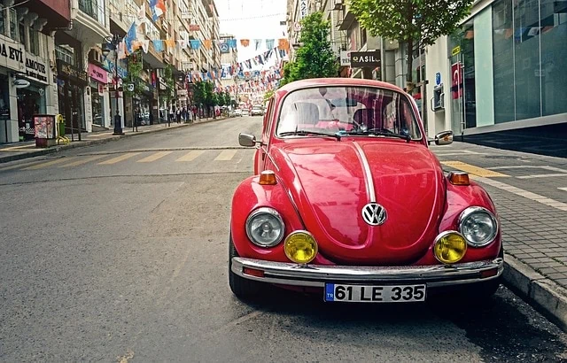 Une Volkswagen Beetle rouge garée sur le côté d'une rue.