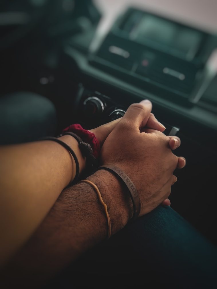 Un homme et une femme se tenant la main dans une voiture.