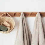 Un support en bois pour serviettes et un panier suspendu.