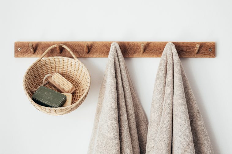 Un support en bois pour serviettes et un panier suspendu.