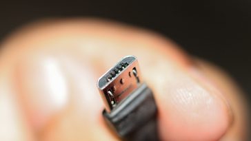 La main d'une personne tenant un câble micro USB.