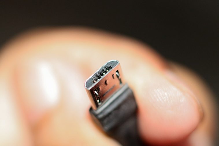 La main d'une personne tenant un câble micro USB.