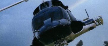 Un hélicoptère volant dans le ciel avec un arc-en-ciel en arrière-plan.
