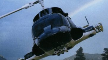 Un hélicoptère volant dans le ciel avec un arc-en-ciel en arrière-plan.