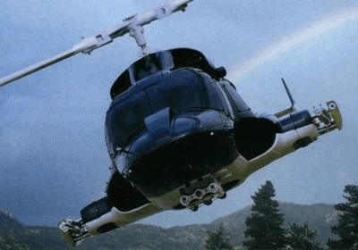 Un hélicoptère volant dans le ciel avec un arc-en-ciel en arrière-plan.