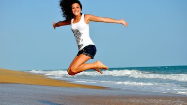 Une femme sautant en l’air sur une plage.