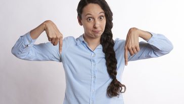 Une femme pointant ses doigts en l’air.