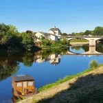 Un bateau est amarré dans une rivière à côté d'un pont.