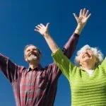 Un couple âgé exprimant sa joie et son bonheur tout en embrassant le concept de bien-être et de confort personnel.