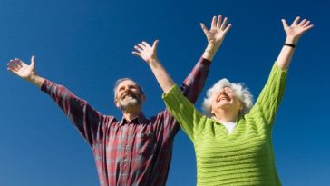 Un couple âgé exprimant sa joie et son bonheur tout en embrassant le concept de bien-être et de confort personnel.