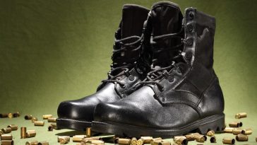 Une paire de bottes militaires noires sur fond vert, qui respire l'élégance.