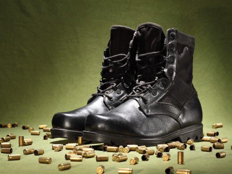 Une paire de bottes militaires noires sur fond vert, qui respire l'élégance.