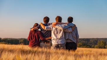 Quatre amis réunis dans un champ de blé.