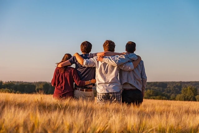 Quatre amis réunis dans un champ de blé.