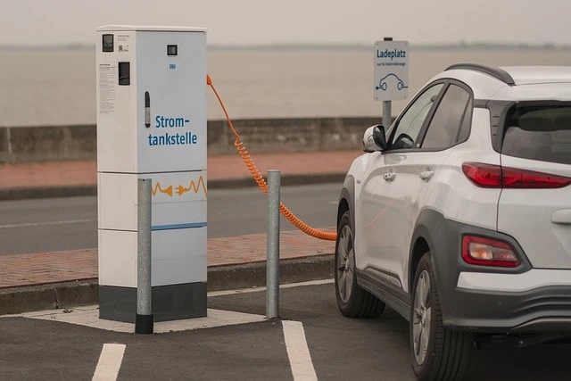 Une voiture électrique blanche est branchée sur une borne de recharge.