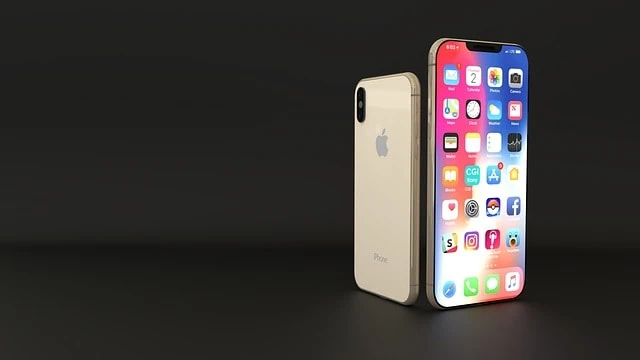 iPhone X doré debout à côté de son reflet vertical sur une surface sombre, intégrant des applications sociales innovantes.