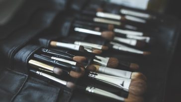Un coffret de pinceaux de maquillage soigneusement rangés dans un étui noir, indispensable pour adopter une routine de maquillage des peaux à graminées.