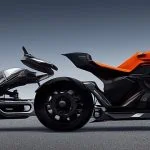Deux motos électriques futuristes aux designs épurés et aux couleurs noir et orange sont exposées côte à côte sur une surface grise sur fond uni.