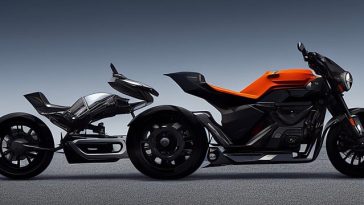 Deux motos électriques futuristes aux designs épurés et aux couleurs noir et orange sont exposées côte à côte sur une surface grise sur fond uni.