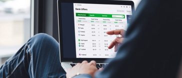 Une personne utilise un ordinateur portable pour consulter un tableau comparatif des offres des banques en ligne, y compris les taux d'intérêt comparatifs 2025 et les offres de remise en argent, dans une application de gestion financière.